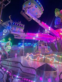 an amusement park at night with lights and rides