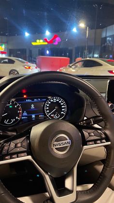 the interior of a car with steering wheel and gauges on display in a showroom