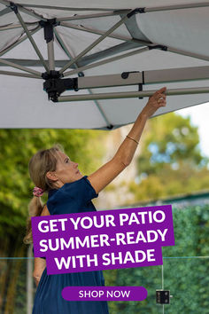 a woman holding up a purple sign that says get your patio summer - ready with shade