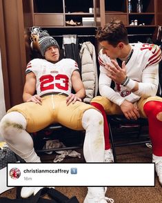 two football players sitting in chairs with their hands together