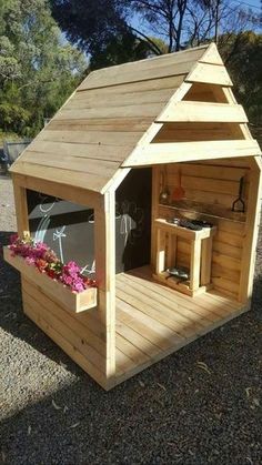 a small wooden building with flowers in it