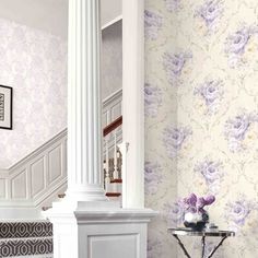 a room with floral wallpaper and purple flowers on the walls, along with a white fireplace mantel