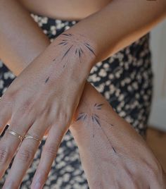 a woman's arm with tattoos on it and her hand holding the other arm