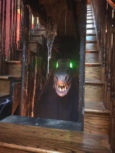 a scary looking animal with green eyes and mouth lights is seen through an open door