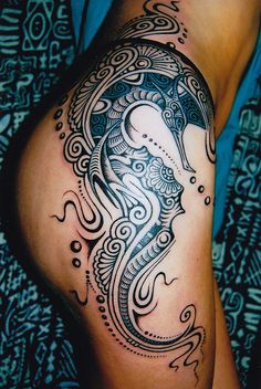 a woman's thigh with an intricate tattoo design on it