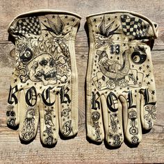 two gloves with designs on them sitting on top of a wooden table next to each other