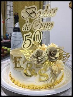 a 50th birthday cake with roses and gold lettering