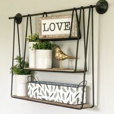 two shelves with plants and decorative items on them, one shelf has a love sign above it