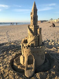 a sand castle on the beach with people in the background