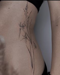 a woman's stomach with a flower tattoo on it