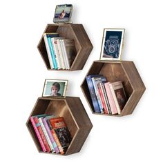 three wooden hexagonal shelves with books on them