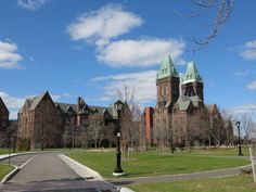 a large building with two towers on the top and green grass in front of it