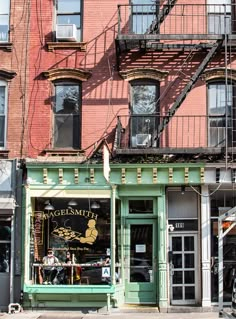 an old building with many windows and stairs on the side walk in front of it