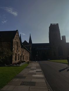 a person is walking down the street in front of an old building with tall towers