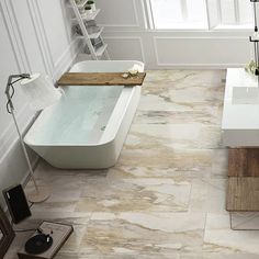 a bath tub sitting next to a white sink in a bathroom on top of a tiled floor