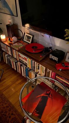 a living room with a television, record player and bookshelf full of cds