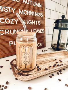 there is a glass jar with coffee in it on the table next to a sign