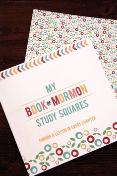 the book of mormon study squares is open on top of a wooden table with colorful circles