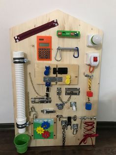 a toy house made out of wood with various items attached to it