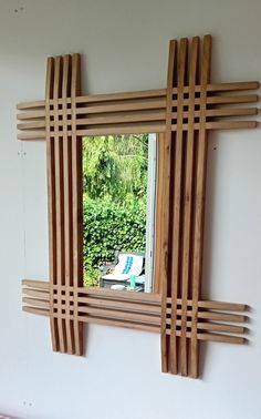 a mirror made out of wood sticks on the wall