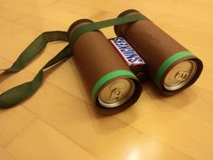 two cans are wrapped in green tape and sitting on the floor