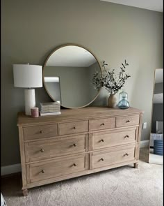 a dresser with a mirror and vase on top