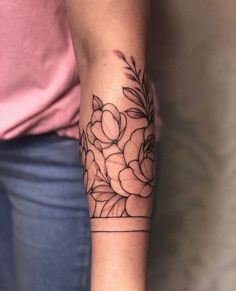 a woman's arm with flowers on it and a line work style tattoo design