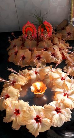 an arrangement of flowers and candles on a table