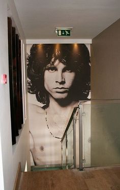 an image of a man with long hair on the wall next to a stairway way