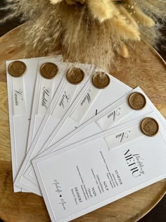 five envelopes with coins on them sitting next to a vase filled with dried flowers