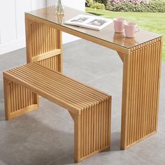 a wooden bench sitting next to a glass table