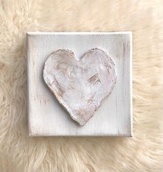 a white heart painted on a wooden block