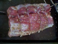 raw meat being cooked in an oven with tongs on the side and seasoning sprinkles all over it