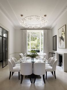 a dining room table surrounded by white chairs