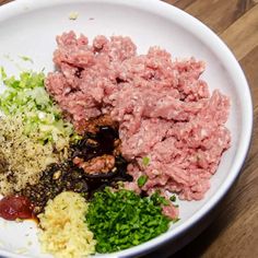 a white plate topped with meat and veggies on top of a wooden table