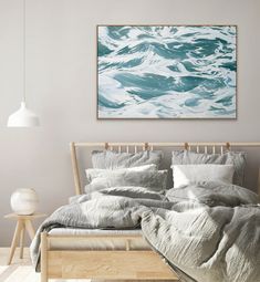 a bed sitting under a painting on top of a wall