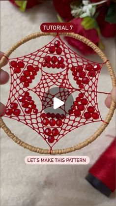 the video shows how to make an ornament with red beads and wood hoop