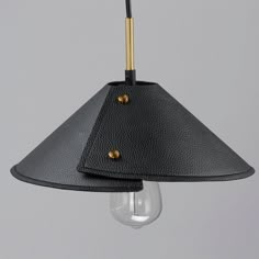 a black lamp hanging from the ceiling with a light bulb on it's side