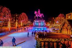 people skating on an ice rink at night with christmas lights and decorations in the background