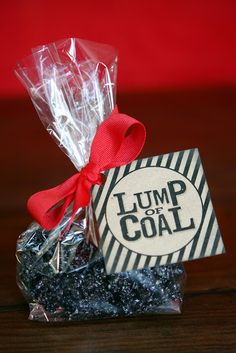 a candy bar wrapped in cellophane and tied with a red ribbon, sits on a wooden table