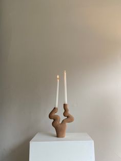 two candles sitting on top of a white box