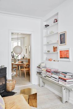 a living room filled with lots of furniture and books on top of a wooden table