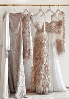 three dresses hanging up in front of a mirror