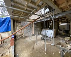 an unfinished room with scaffolding on the ceiling and walls, including a wheelbarrow