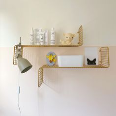 two shelves with items on top of each other and a lamp next to them in the corner