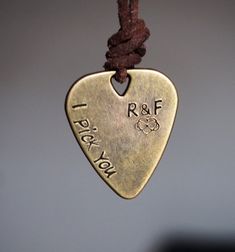 a brass guitar pick hanging from a string