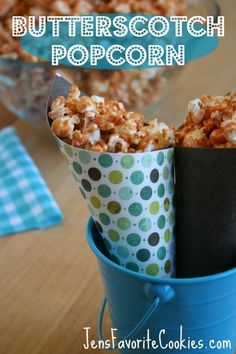 a blue bucket filled with popcorn sitting on top of a table