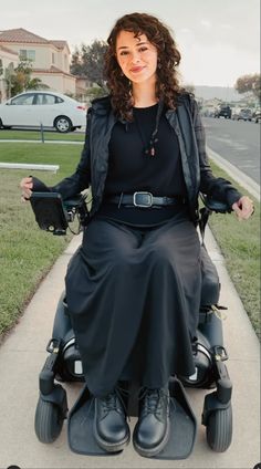 a woman in a black dress is sitting on an electric scooter with wheels