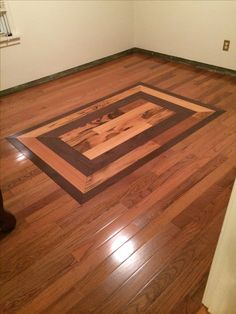 an empty room with hard wood flooring and white walls