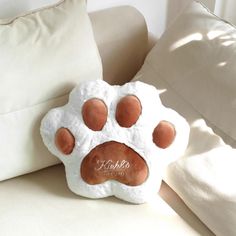 a stuffed animal paw pillow sitting on top of a couch